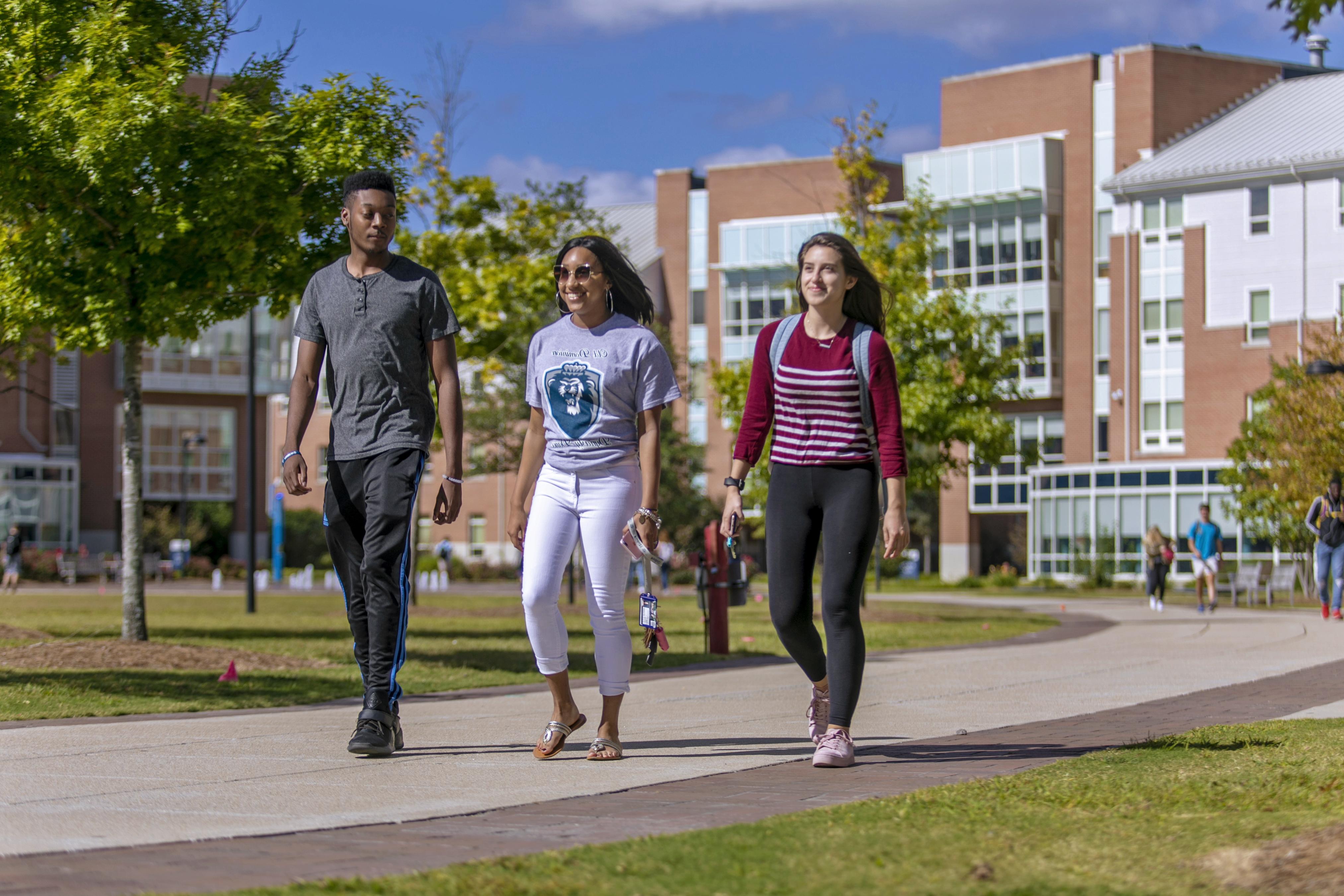 Three students talking outside University Quad.